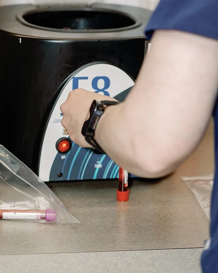 A Noah’s Ark technician loading a blood sample into the in-house centrifuge