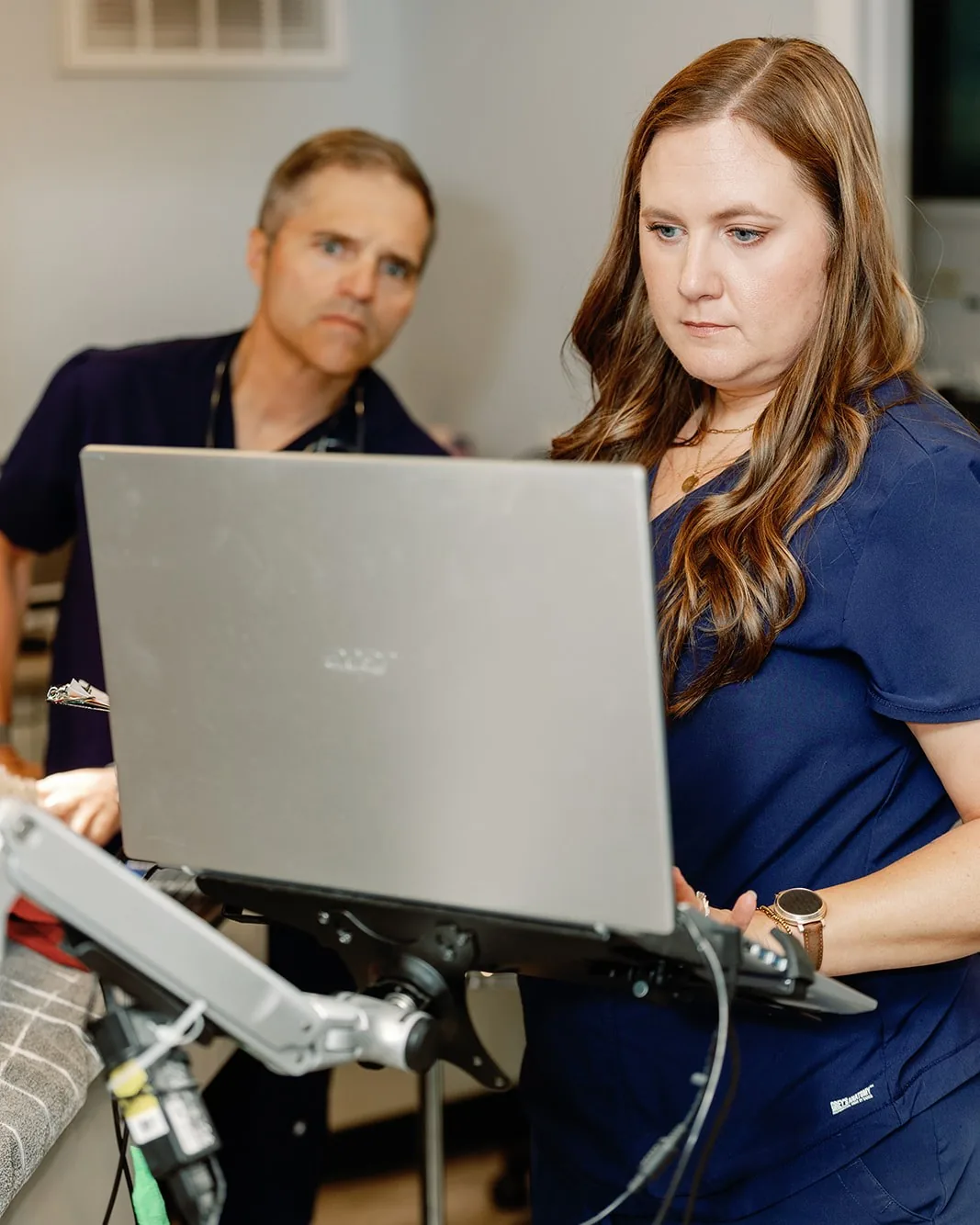 A technician bringing up a digital dental radiograph while a veterinarian reviews it