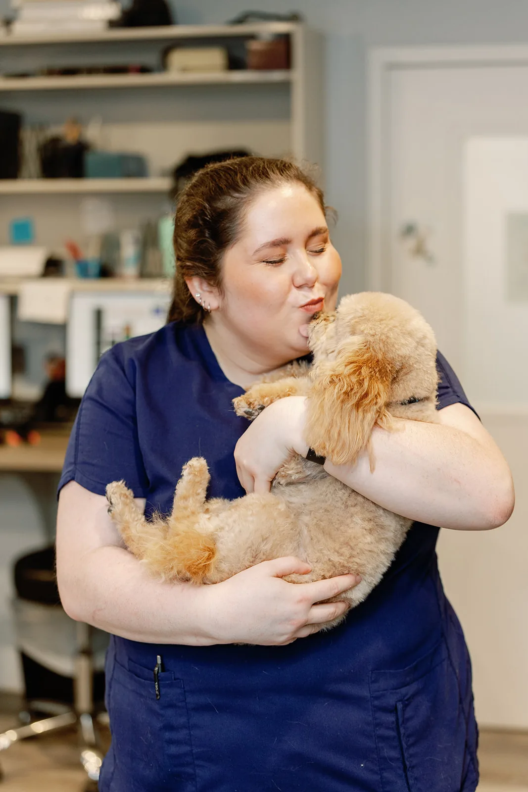 A Noah's Ark team member holding a poodle puppy close