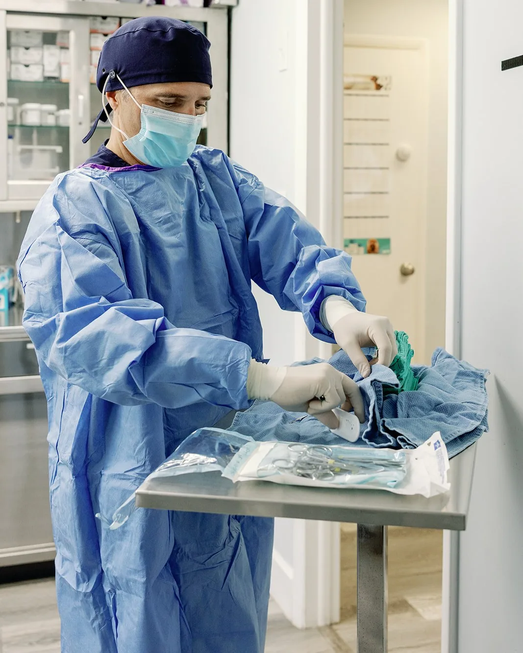 A surgeon opening a sterile instrument pack before a procedure